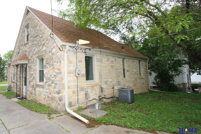 2727 S 19th St, Lincoln, NE 68502 - view of home's exterior with stone siding, central AC, and a shingled roof