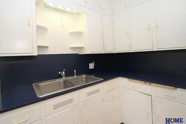 2727 S 19th St, Lincoln, NE 68502 - kitchen featuring open shelves, a sink, white cabinetry, and dark countertops