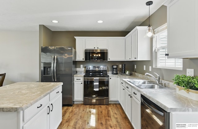 6031 N 167th Ct, Omaha, NE 68116 - kitchen with stainless steel appliances, a sink, light countertops, light wood-style flooring, and white cabinetry