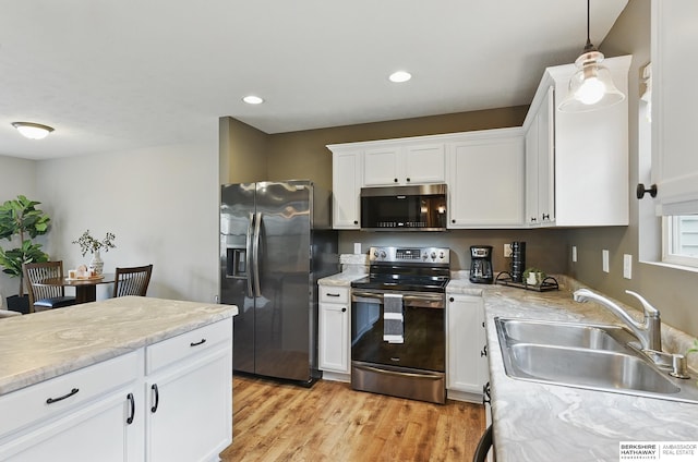 6031 N 167th Ct, Omaha, NE 68116 - kitchen featuring appliances with stainless steel finishes, a sink, white cabinetry, light wood-type flooring, and recessed lighting
