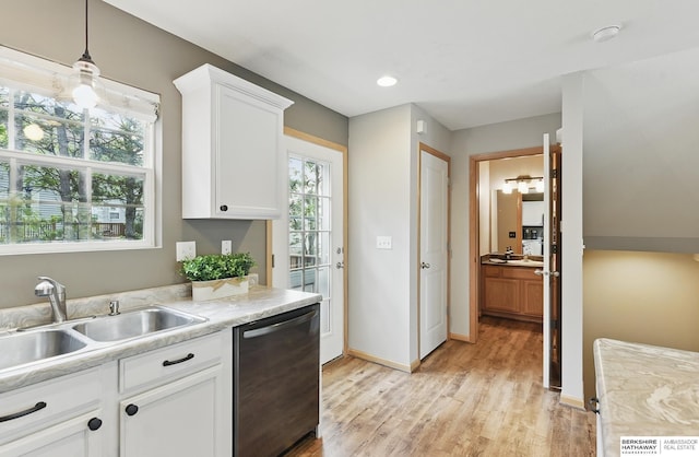 6031 N 167th Ct, Omaha, NE 68116 - kitchen with stainless steel dishwasher, a sink, light countertops, light wood-type flooring, and white cabinets
