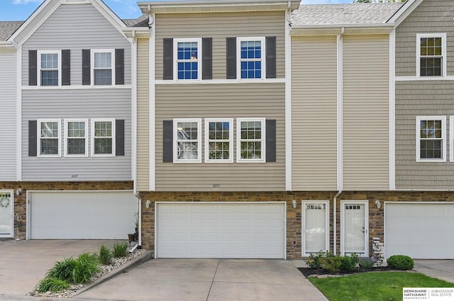 6031 N 167th Ct, Omaha, NE 68116 - townhome / multi-family property featuring a garage, driveway, and stone siding
