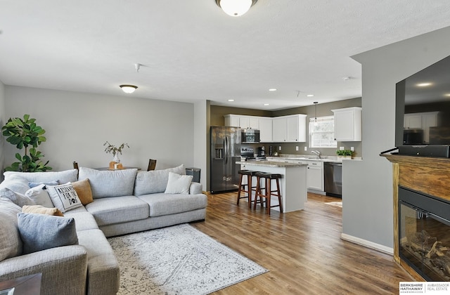 6031 N 167th Ct, Omaha, NE 68116 - living area with wood finished floors, recessed lighting, and a glass covered fireplace