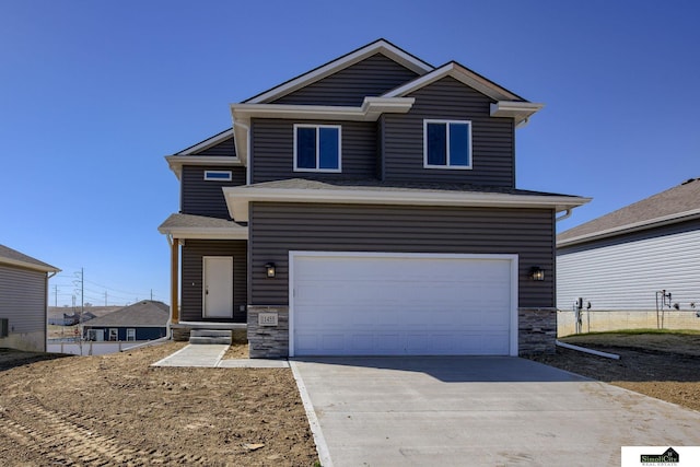 view of front of house featuring a garage, concrete driveway, and stone siding