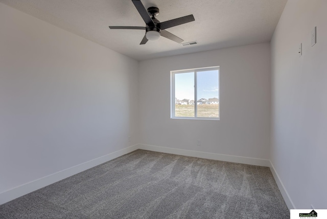 carpeted empty room featuring ceiling fan and baseboards