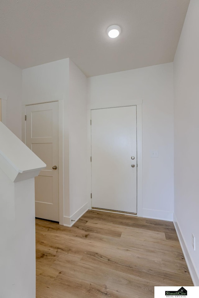 entryway featuring light wood-type flooring and baseboards