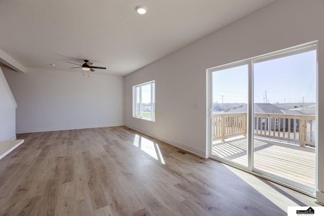 unfurnished room with a ceiling fan, light wood-style flooring, and baseboards