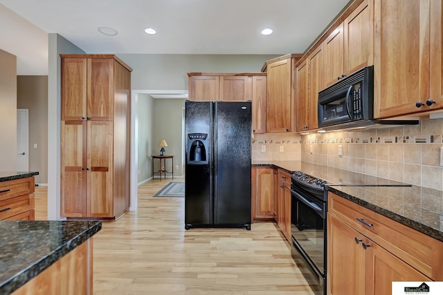 8420 Augusta Dr, Lincoln, NE 68526 - kitchen with black appliances, light wood-style floors, decorative backsplash, baseboards, and dark stone counters
