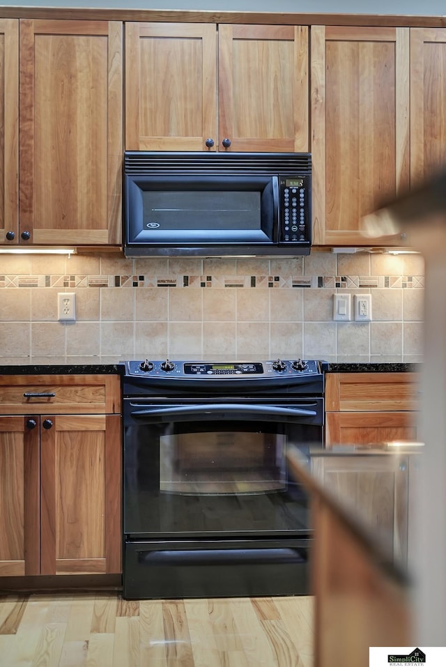 8420 Augusta Dr, Lincoln, NE 68526 - kitchen with black appliances, tasteful backsplash, and dark stone counters