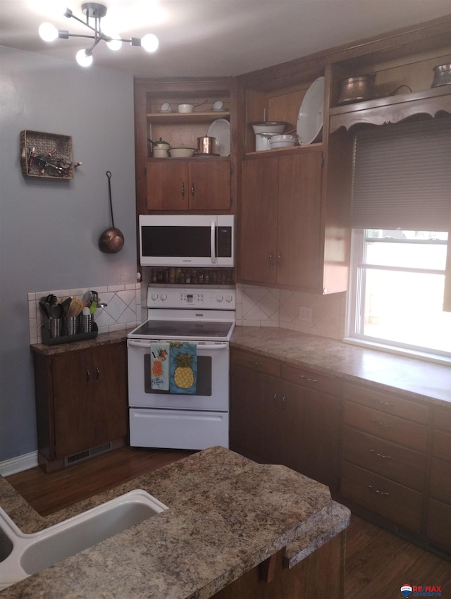 803 6th St, Fairbury, NE 68352 - kitchen with white appliances, tasteful backsplash, a chandelier, dark wood-style floors, and a sink