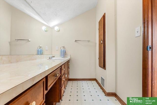 4188 Chicago St, Omaha, NE 68131 - bathroom with tile patterned floors, lofted ceiling, vanity, baseboards, and a textured ceiling