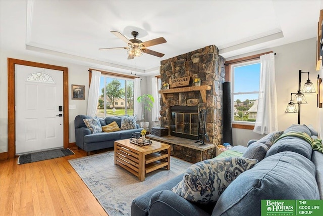 4188 Chicago St, Omaha, NE 68131 - living room featuring a tray ceiling, wood finished floors, a ceiling fan, and a fireplace