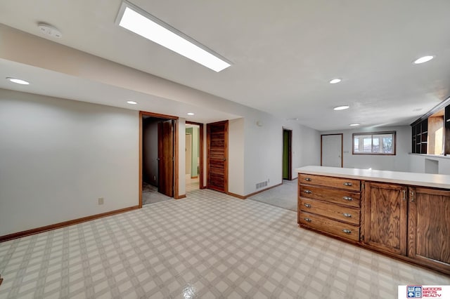 4932 High St, Lincoln, NE 68506 - kitchen featuring light countertops, baseboards, recessed lighting, brown cabinetry, and open floor plan