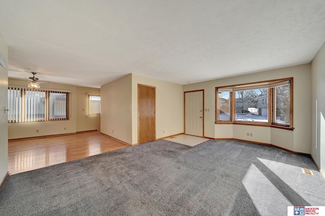 4932 High St, Lincoln, NE 68506 - unfurnished living room with carpet flooring, baseboards, and ceiling fan