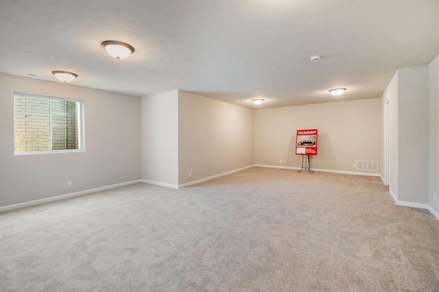 unfurnished room featuring light colored carpet, baseboards, and a smoke detector