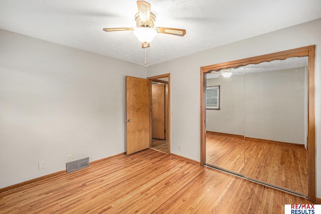 2137 S 49th St, Omaha, NE 68106 - unfurnished bedroom with wood finished floors, baseboards, a closet, and ceiling fan