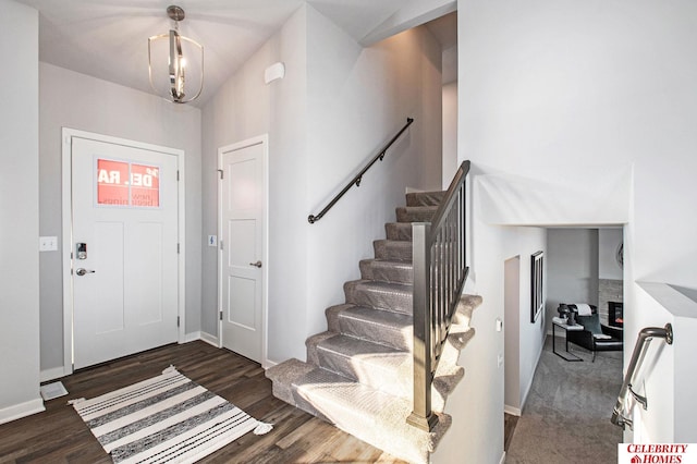 entrance foyer with wood finished floors, baseboards, and stairway