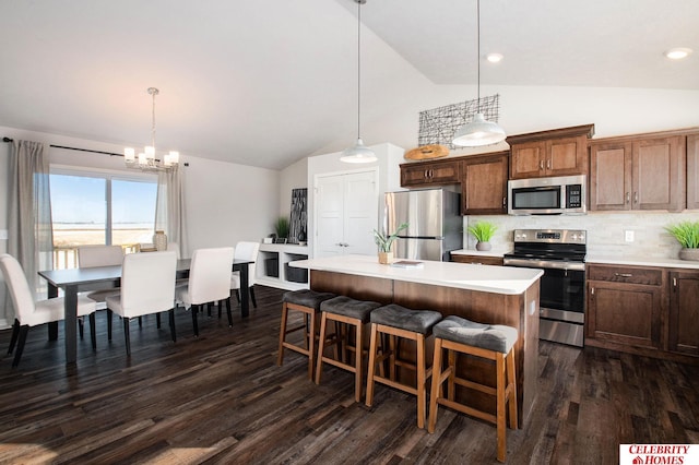 kitchen featuring appliances with stainless steel finishes, light countertops, a chandelier, high vaulted ceiling, and dark wood finished floors