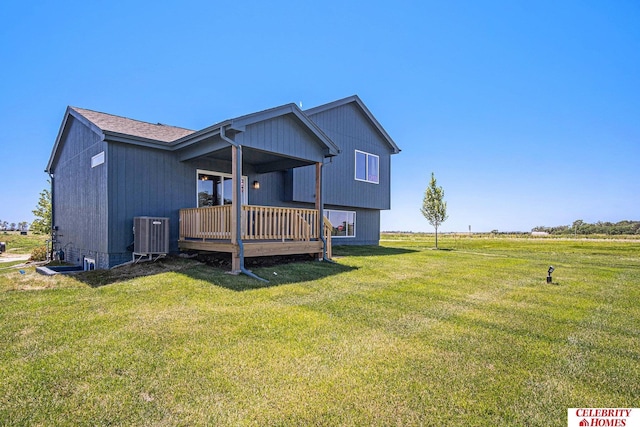 back of house featuring cooling unit, a lawn, and a wooden deck