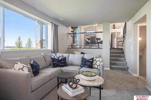 living room featuring carpet, baseboards, and stairs