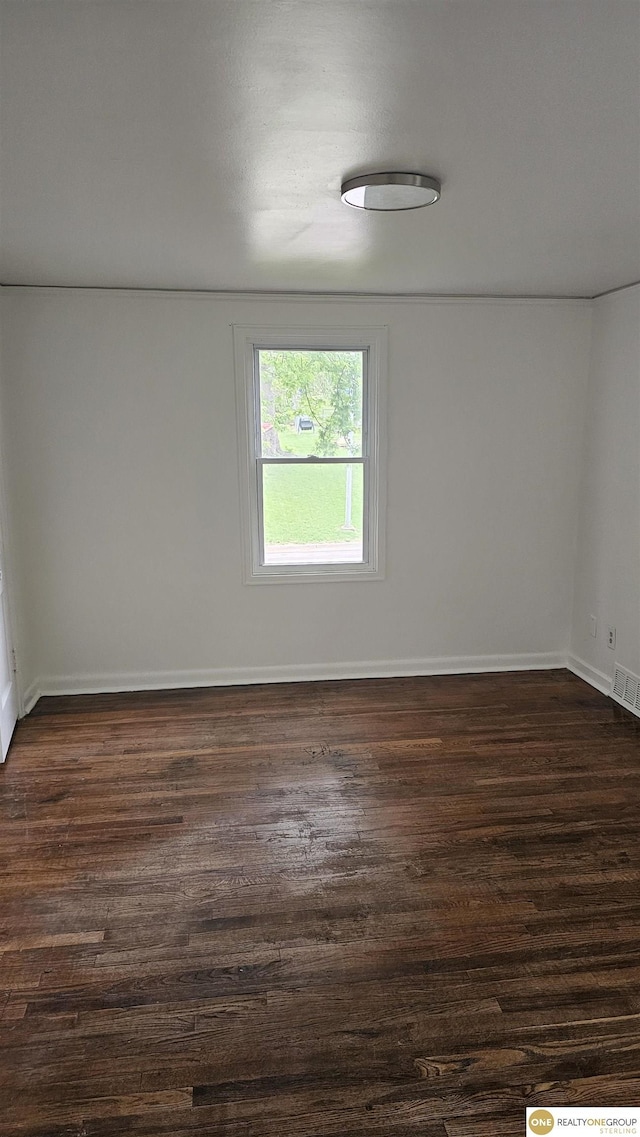unfurnished room with dark wood-style flooring and baseboards