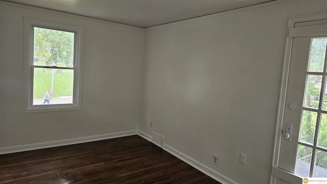 spare room with healthy amount of natural light, baseboards, dark wood-style floors, and crown molding
