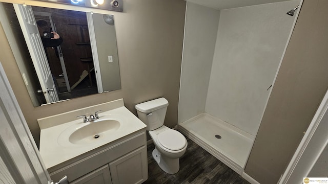 full bath featuring toilet, a shower stall, vanity, and wood finished floors