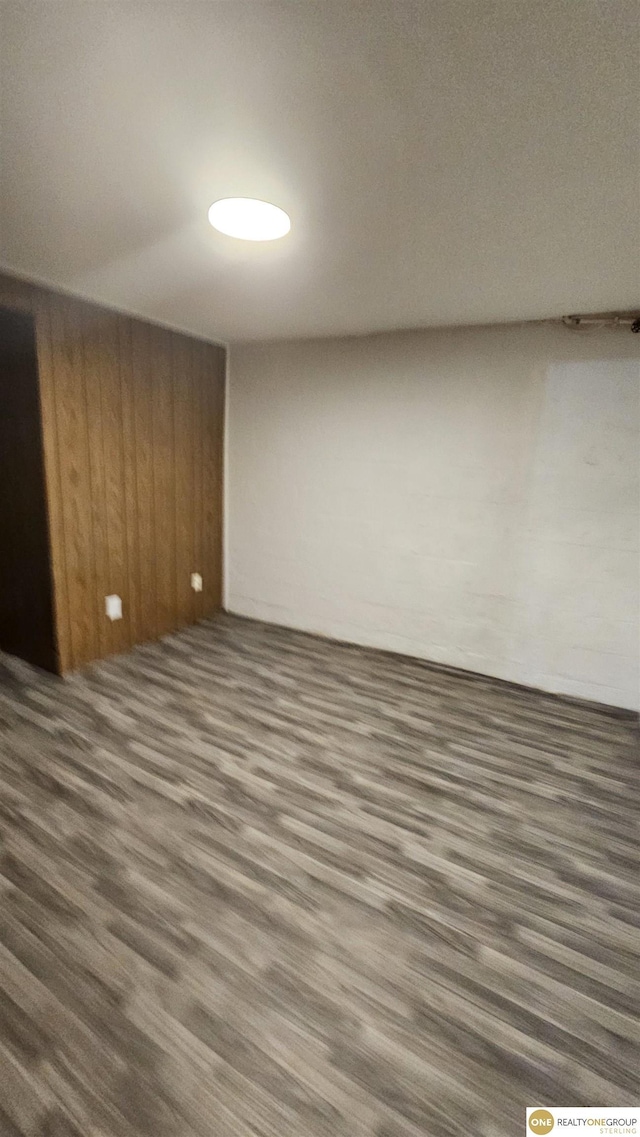 spare room with wood finished floors and wooden walls
