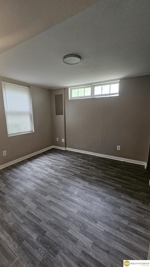 unfurnished room featuring dark wood-style floors and baseboards