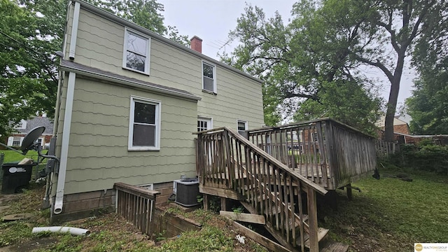 back of property featuring central AC unit, a wooden deck, a chimney, and stairway