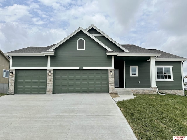 view of front of house with concrete driveway, a front yard, a garage, and a shingled roof