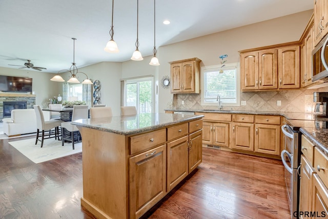 7320 S 169th St, Omaha, NE 68136 - kitchen with range with two ovens, ceiling fan, a sink, light stone counters, and recessed lighting
