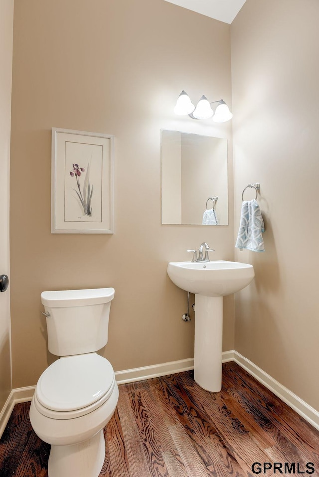 7320 S 169th St, Omaha, NE 68136 - half bathroom featuring wood finished floors, baseboards, toilet, and a sink