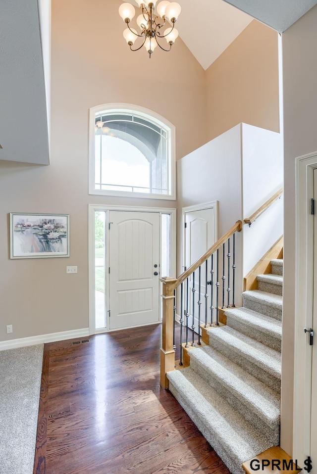 7320 S 169th St, Omaha, NE 68136 - foyer with high vaulted ceiling, a chandelier, stairs, baseboards, and wood finished floors