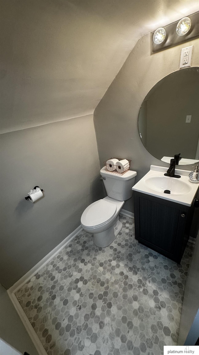 half bathroom featuring toilet, baseboards, tile patterned floors, and vanity