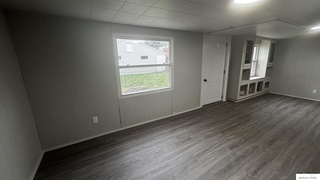 empty room featuring dark wood-type flooring and baseboards