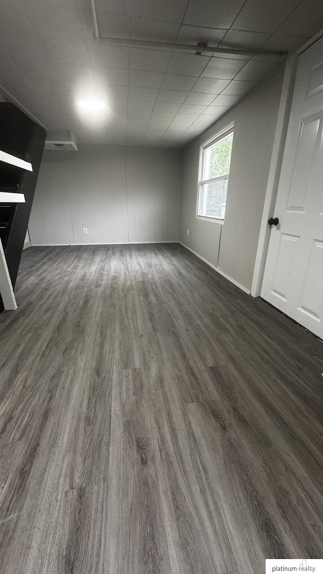 unfurnished room featuring dark wood-type flooring and baseboards
