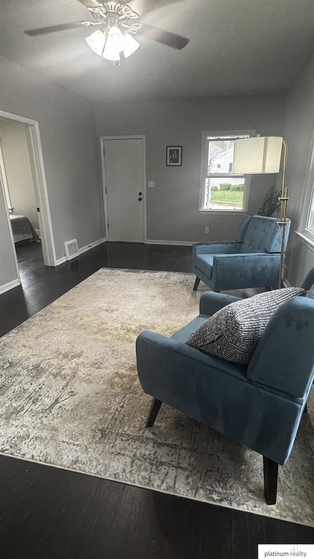 living area with wood finished floors, ceiling fan, and baseboards