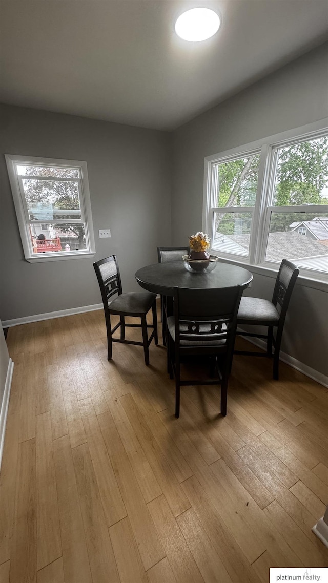 dining room featuring light wood-type flooring and baseboards