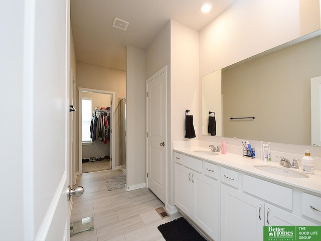 bathroom with double vanity, a spacious closet, baseboards, and tile patterned floors