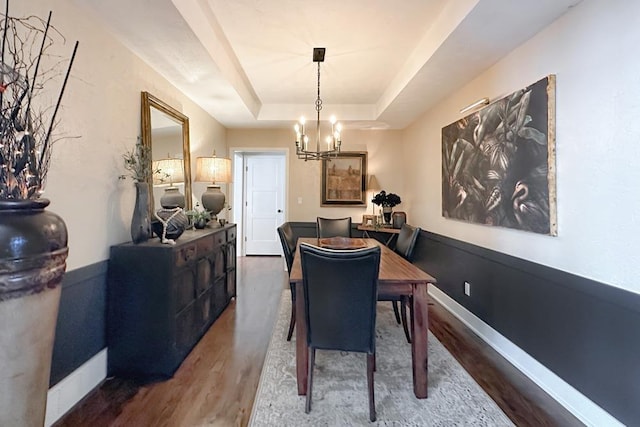 7815 Maui Cir, Papillion, NE 68046 - dining area with wood finished floors, a chandelier, a tray ceiling, and baseboards