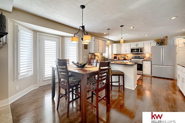 7815 Maui Cir, Papillion, NE 68046 - dining room featuring plenty of natural light, wood finished floors, baseboards, recessed lighting, and a textured ceiling