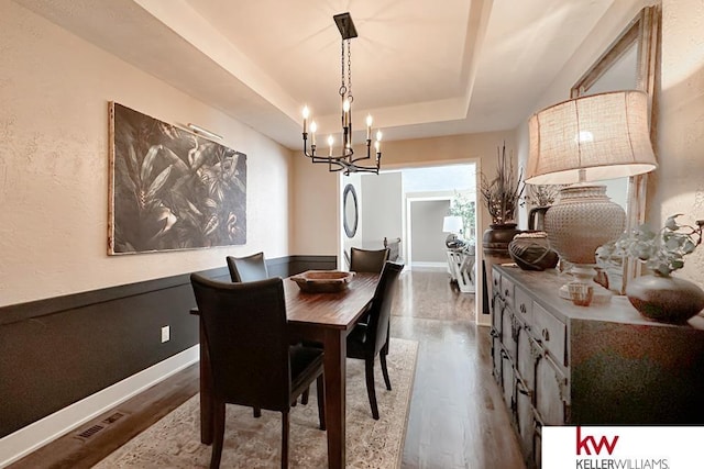 7815 Maui Cir, Papillion, NE 68046 - dining room with a chandelier, a raised ceiling, wood finished floors, and baseboards