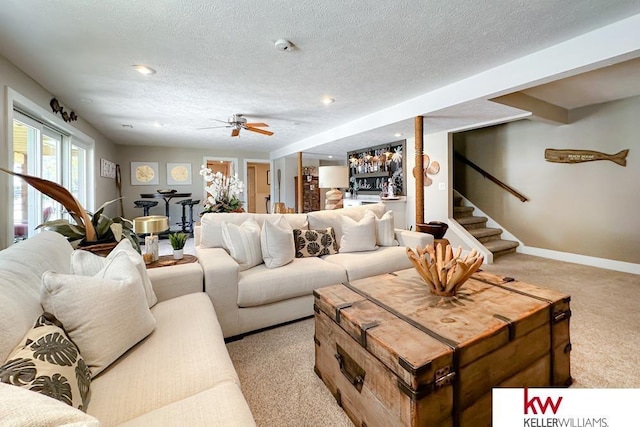 7815 Maui Cir, Papillion, NE 68046 - living room featuring light carpet, ceiling fan, baseboards, stairway, and a textured ceiling