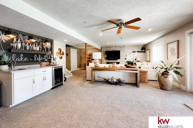 7815 Maui Cir, Papillion, NE 68046 - living room with wine cooler, wet bar, a textured ceiling, light carpet, and ceiling fan