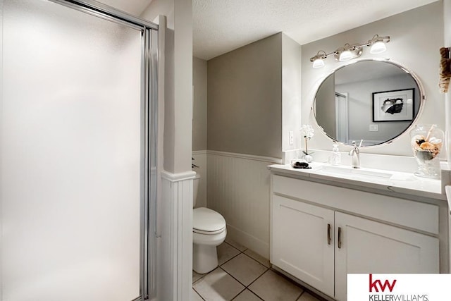 7815 Maui Cir, Papillion, NE 68046 - full bathroom featuring wainscoting, toilet, tile patterned floors, vanity, and a textured ceiling
