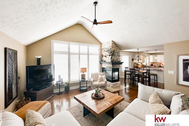 7815 Maui Cir, Papillion, NE 68046 - living room featuring ceiling fan, a textured ceiling, a stone fireplace, vaulted ceiling, and plenty of natural light