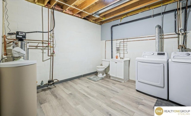 19882 Chicago St, Elkhorn, NE 68022 - laundry area with washing machine and dryer, concrete block wall, light wood-style floors, and cabinet space