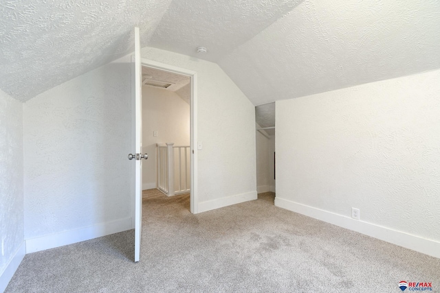 3021 N St, Lincoln, NE 68510 - additional living space featuring lofted ceiling, carpet, a textured ceiling, a textured wall, and baseboards