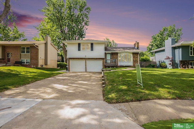 10241 Berry St, Omaha, NE 68127 - split level home featuring an attached garage, brick siding, concrete driveway, and a chimney